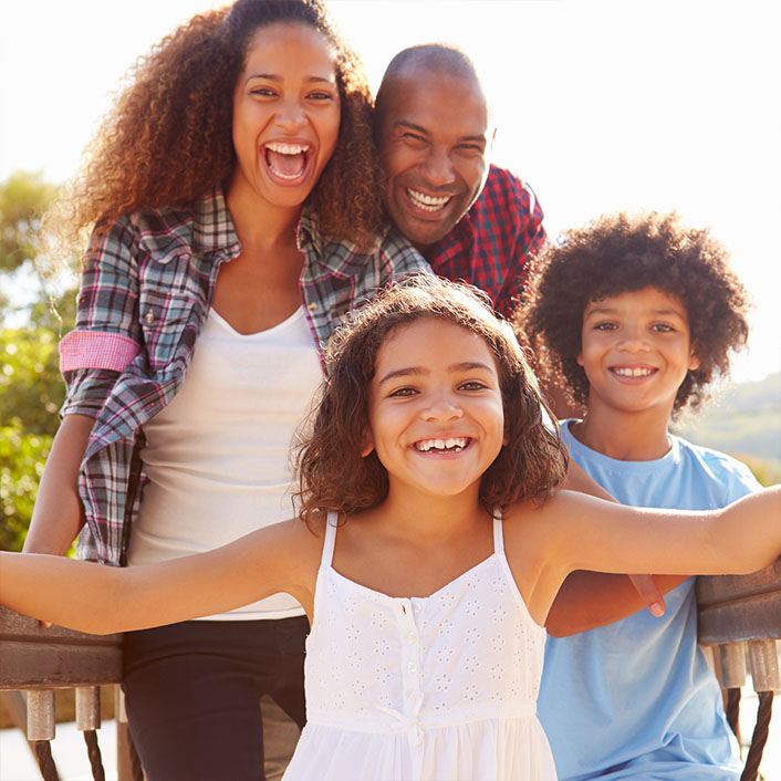 family of four smiling and happy together