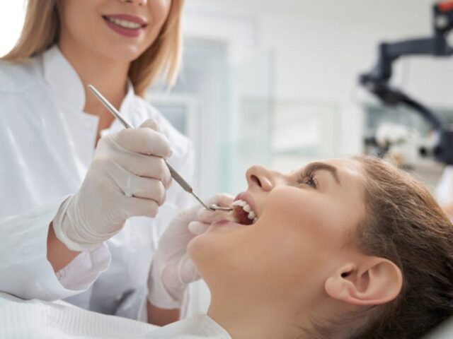 Dentist performing an oral examination on a patient in a modern dental office, highlighting the importance of dental care and procedures like wisdom tooth extraction.